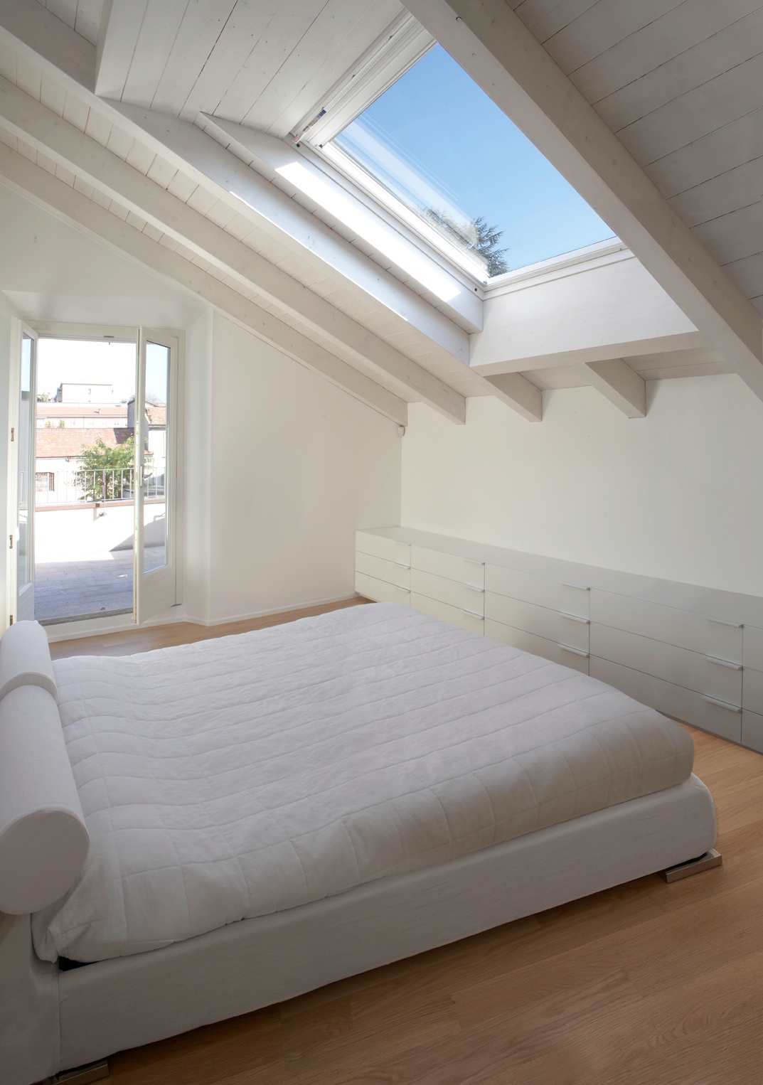 La camera da letto illuminata da finestre per tetti